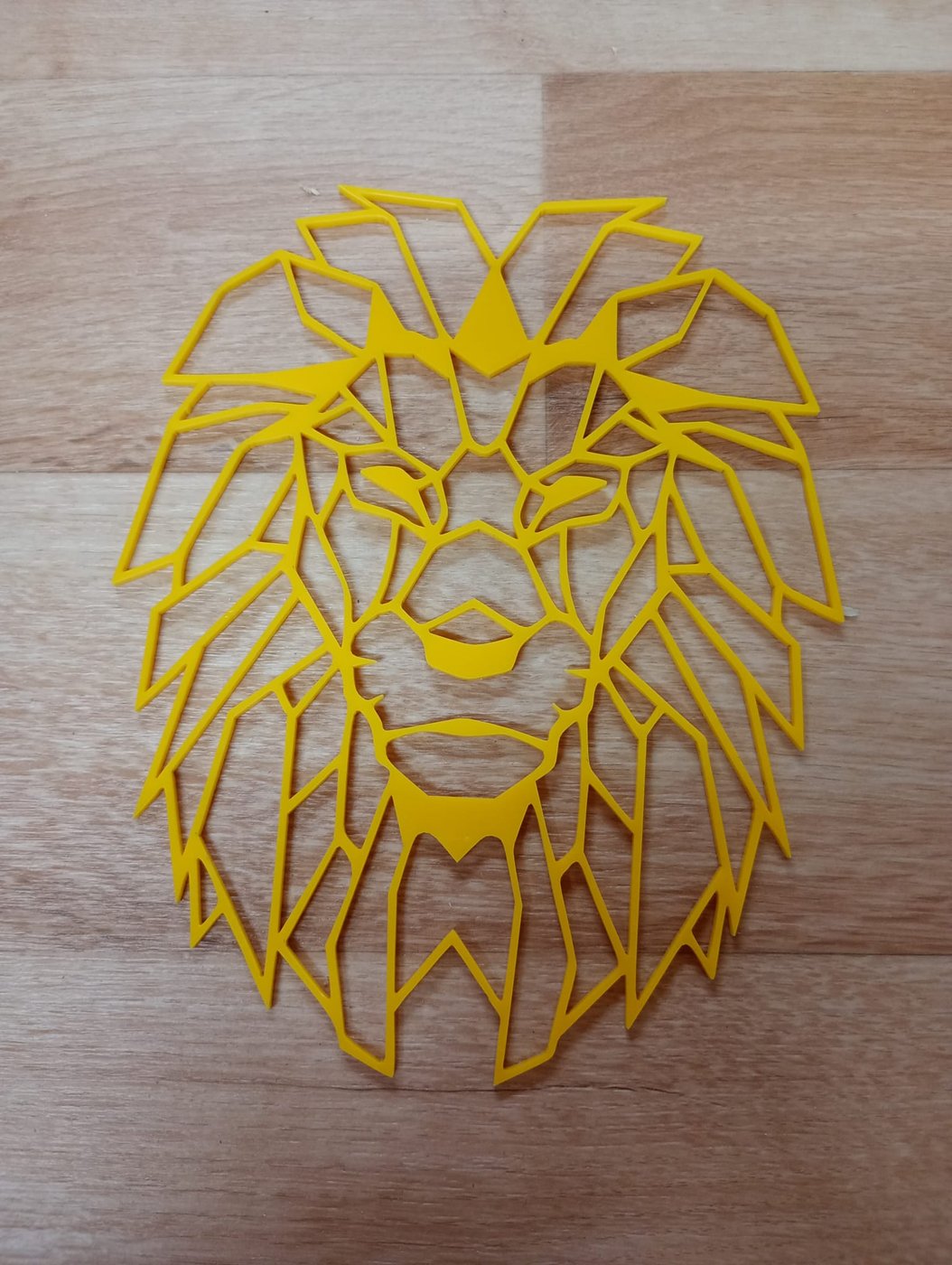 Lion géométrique découpé au laser dans une plaque de plexi jaune