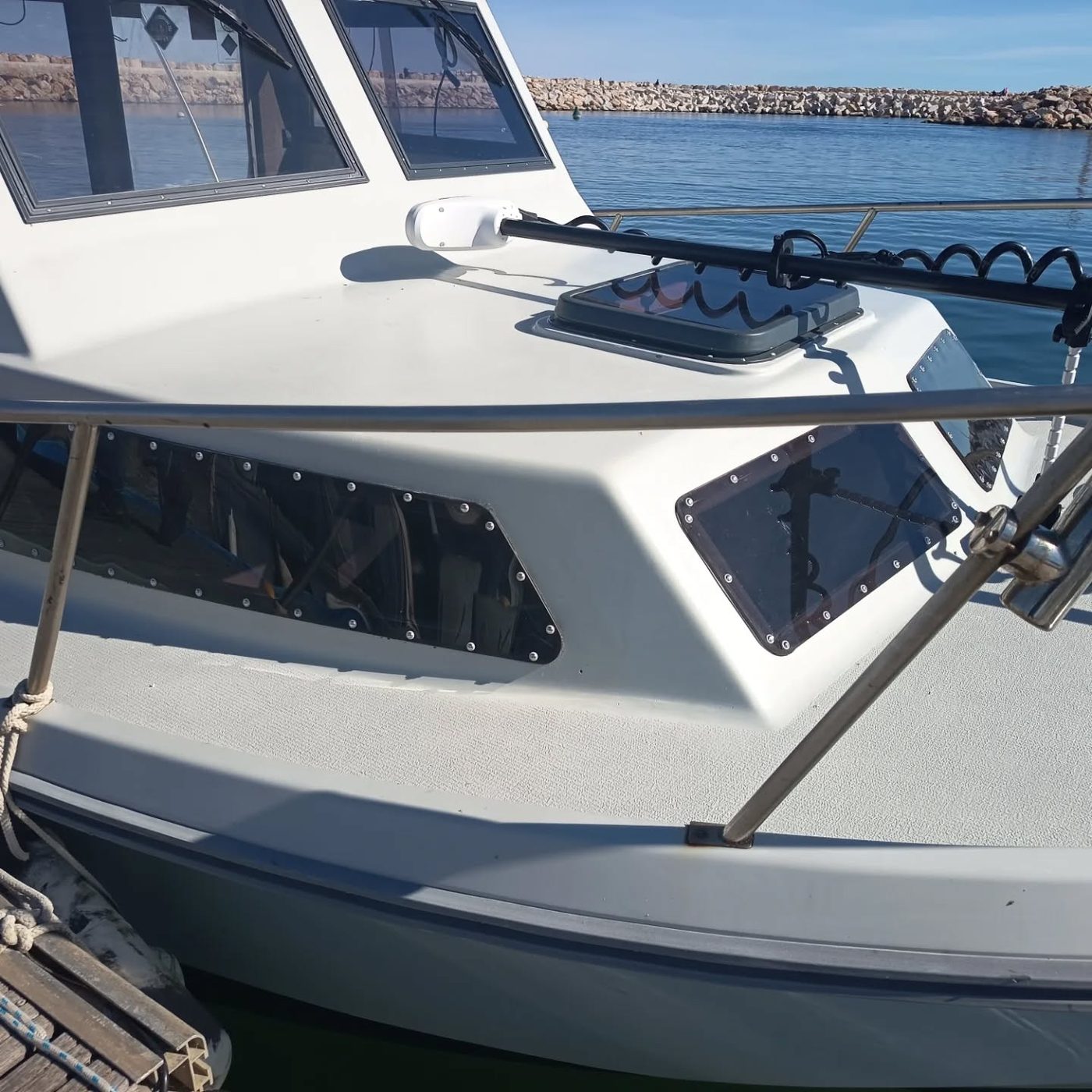 Hublots et panneaux en plexi fumé découpés à la forme sur un bateau au port