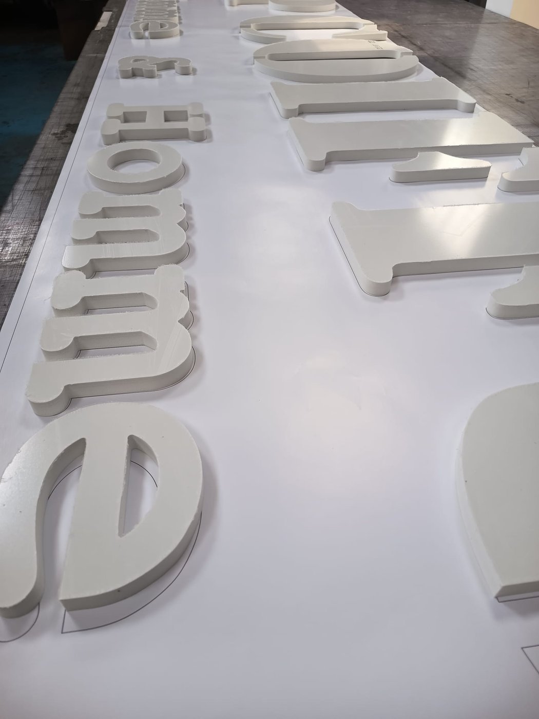 Lettres découpées en PVC en relief, prêtes pour une signalétique, à l’atelier RezoFabrik